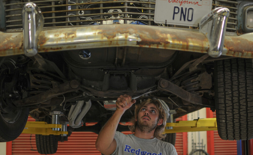 This picture was taken in October, the student is fixing the car at the auto shop class