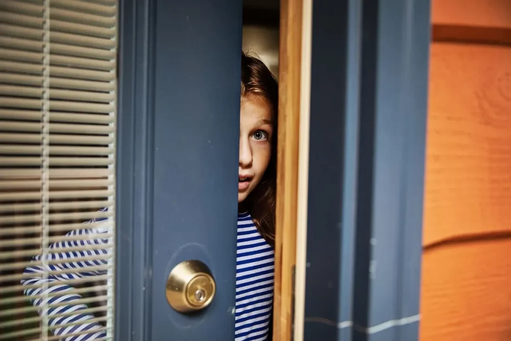 young_girl_opening_front_door_1217632728